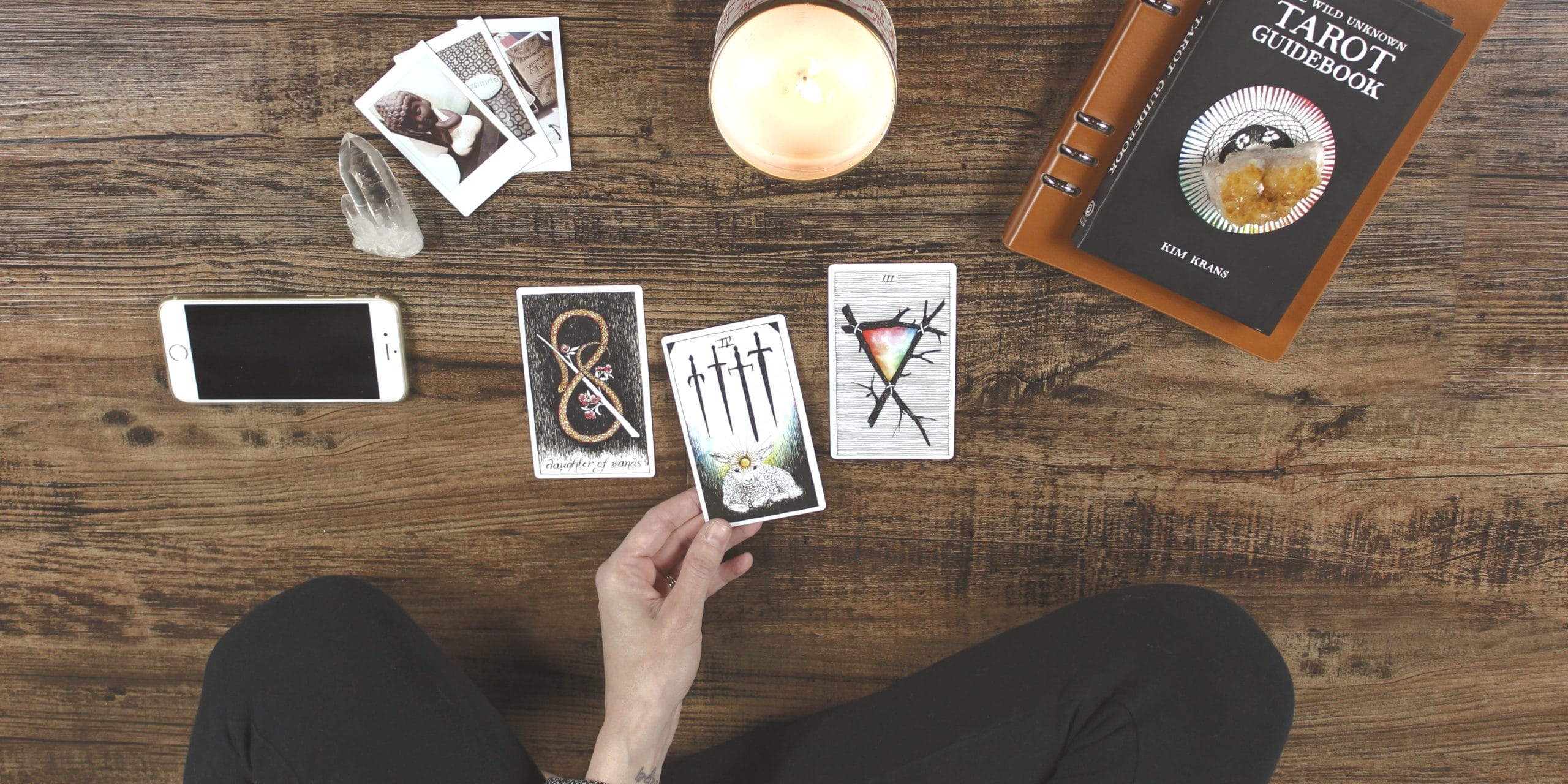 Mano sosteniendo una carta del tarot con símbolos místicos